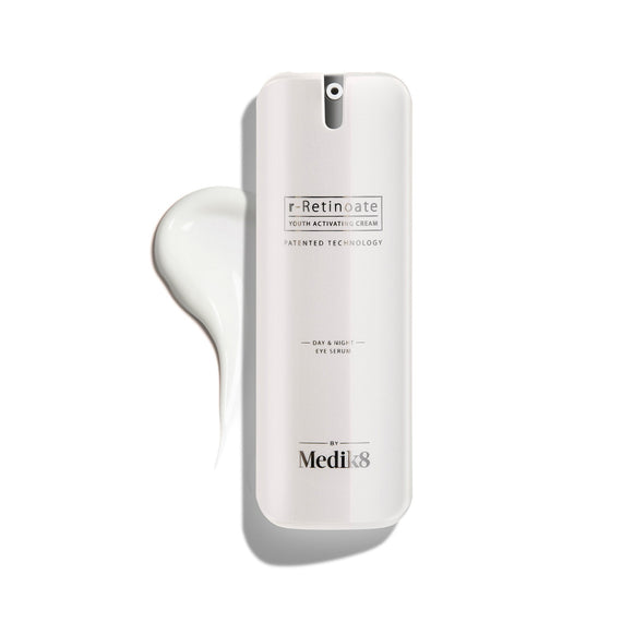 Biała butelka z pompką r-Retinoate Day & Night Eye Serum, z kroplą produktu obok niej.
-39