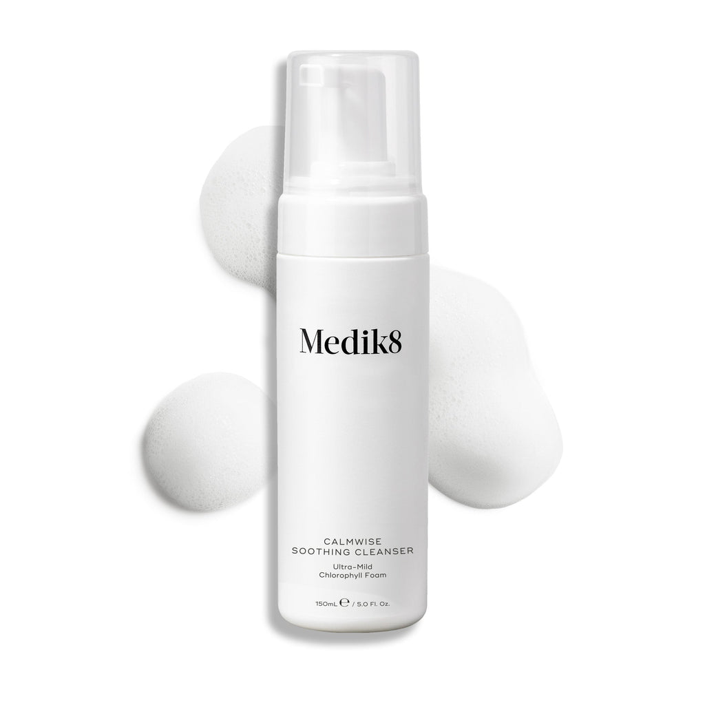 Butelka z pompką Medik8 Calmwise Soothing Cleanser na białym tle, z widoczną smugą białej pianki za produktem, podkreślającą jego konsystencję.
