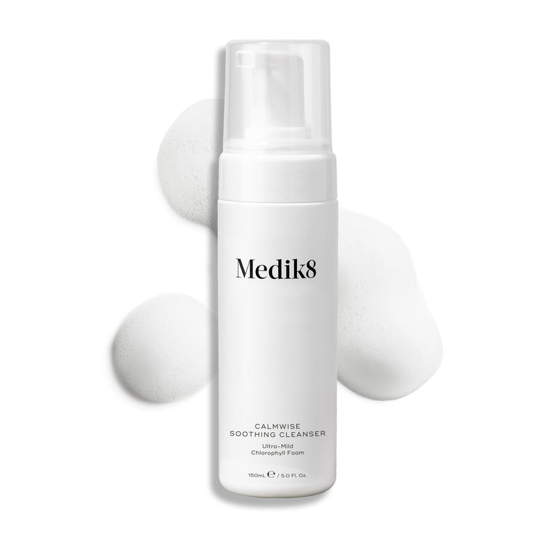 Butelka z pompką Medik8 Calmwise Soothing Cleanser na białym tle, z widoczną smugą białej pianki za produktem, podkreślającą jego konsystencję.
