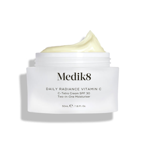Na zdjęciu widać otwarty szklany słoiczek z kremem Medik8 Daily Radiance Vitamin C, na którego powierzchni widoczna jest spora warstwa jasnożółtego kremu. Napis informuje, że jest to krem nawilżający 2 w 1 C-Tetra Cream SPF 30 o pojemności 50 ml.-8