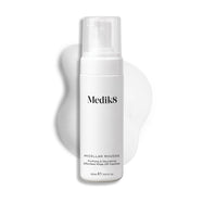 Butelka z pompką Medik8 Micellar Mousse na białym tle z widoczną smugą białej pianki za produktem, podkreślającą jego konsystencję.
