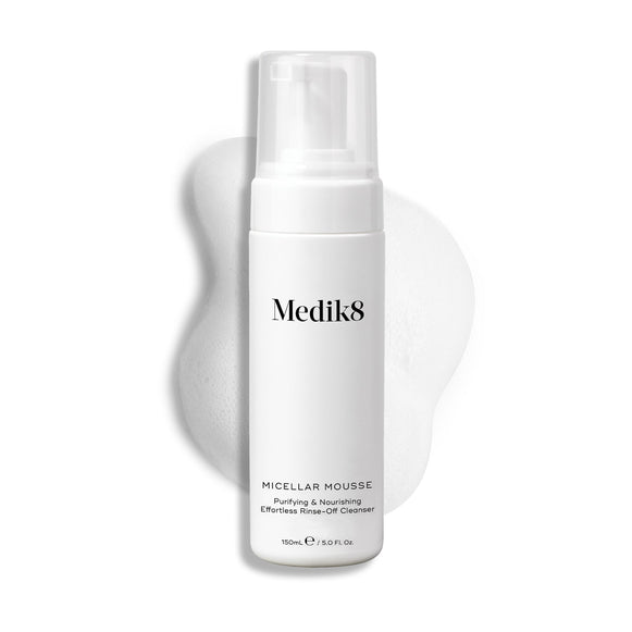 Butelka z pompką Medik8 Micellar Mousse na białym tle z widoczną smugą białej pianki za produktem, podkreślającą jego konsystencję.
-29