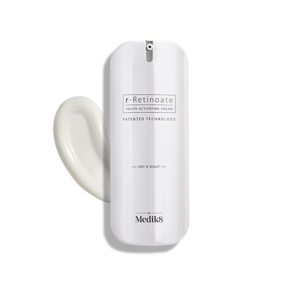 Biała butelka z pompką r-Retinoate Day & Night Eye Serum z kroplą produktu obok niej.
