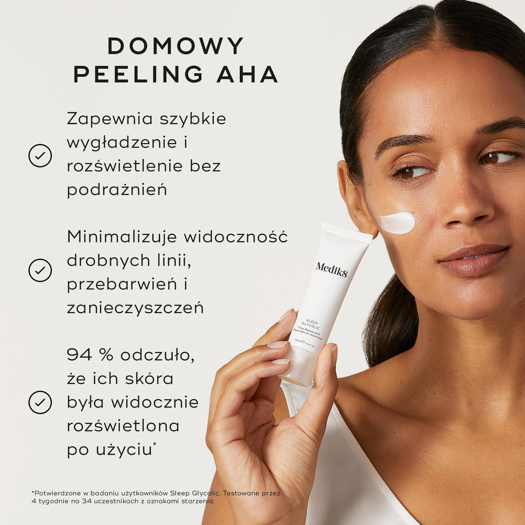 Osoba trzyma tubkę Medik8 Sleep Glycolic na neutralnym, złamanym białym tle, z widoczną smugą białego kremu na policzku. Tekst podkreśla, że jest to domowy peeling AHA, który zapewnia szybkie wygładzenie i rozświetlenie skóry bez podrażnień oraz pomaga zminimalizować widoczność drobnych linii, przebarwień i zanieczyszczeń. Dodatkowo informuje, że 94% osób zauważyło wyraźne rozświetlenie skóry po użyciu.
