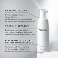 Butelka z pompką Medik8 Clarifying Foam stoi na białym bloku na czystym, szarym tle. Tekst podkreśla kluczowe składniki: kwas salicylowy rozkładający zanieczyszczenia powodujące niedoskonałości, kwas L-migdałowy zapewniający delikatne złuszczanie i bardziej wyrównaną cerę oraz niacynamid i olejek z drzewa herbacianego wspierające utrzymanie zrównoważonej, wolnej od niedoskonałości skóry.
