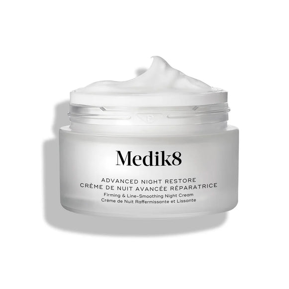 Słoiczek z kremem Medik8 Advanced Night Restore przedstawiony w pozycji otwartej, z obfitą porcją białego kremu uformowaną w kopczyk na wierzchu, na tle czystej bieli, co podkreśla jego gładką, regenerującą konsystencję. Na słoiczku widnieje czarny napis: „Rejuvenating Multi-Ceramide Night Cream”.-2