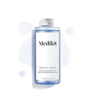 Butelka uzupełniająca (150 ml) toniku Medik8 Press & Clear z srebrną zakrętką, przedstawiona na białym tle z niebieskimi kroplami płynu wokół produktu. Tekst potwierdza, że zawiera łagodnie uwalniający kwas salicylowy.

